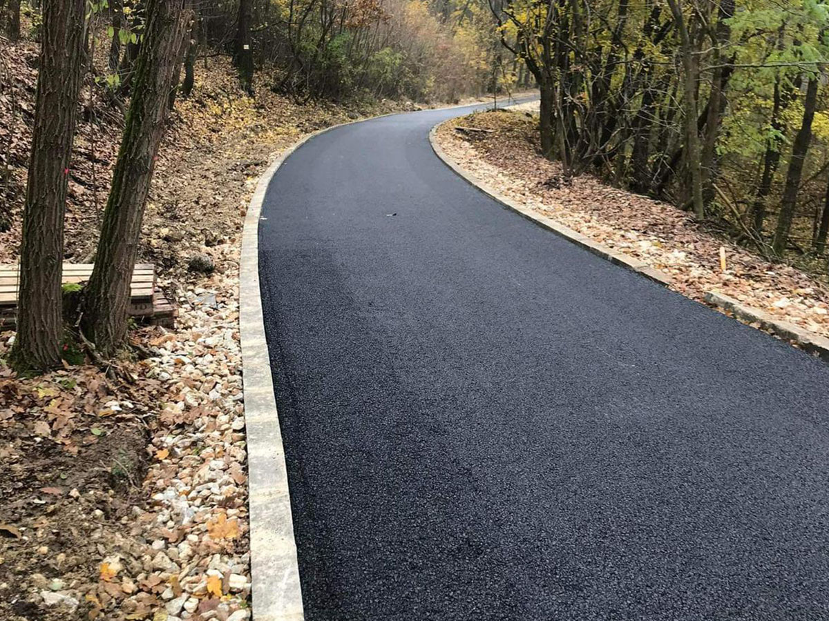 Erdei sétányút aszfaltozása – ívelt pályaszerkezet szegélykővel, őszi erdőben